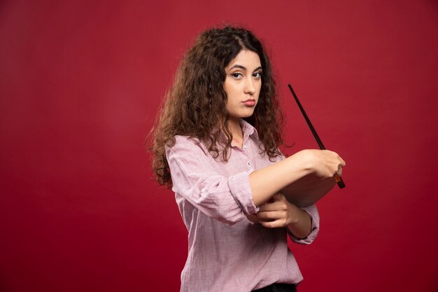 Jeune femme posant avec pinceau et palette de peinture.