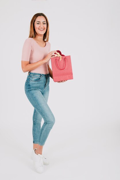 Jeune femme posant avec un sac en papier