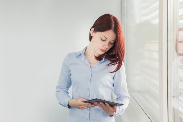 Jeune femme posant avec une tablette