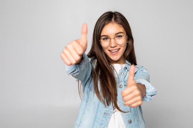 Jeune femme, à, pouces haut, isolé, sur, a, mur blanc