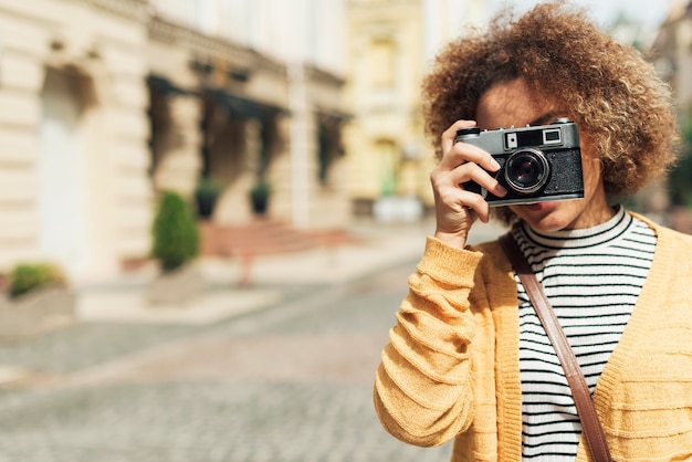 Photo gratuite jeune femme prenant une photo avec un appareil photo avec espace copie