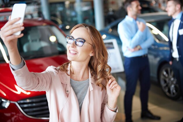 Jeune Femme Prenant Une Photo Chez Le Concessionnaire Automobile