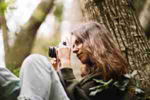 Photo gratuite jeune femme prenant une photo dans la nature