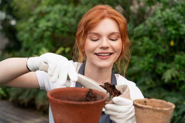 Jeune femme prenant soin de ses plantes dans une serre