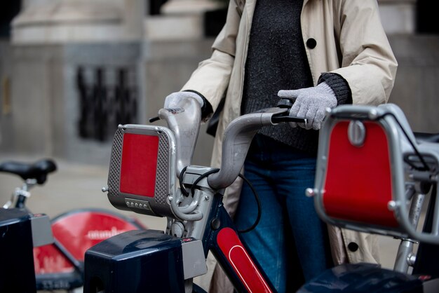 Jeune femme prenant un vélo pour le monter dans la ville