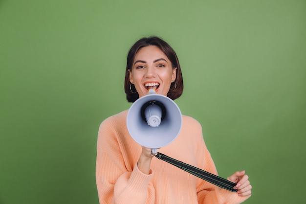 Jeune Femme En Pull Pêche Occasionnel Isolé Sur Un Mur De Couleur Olive Verte