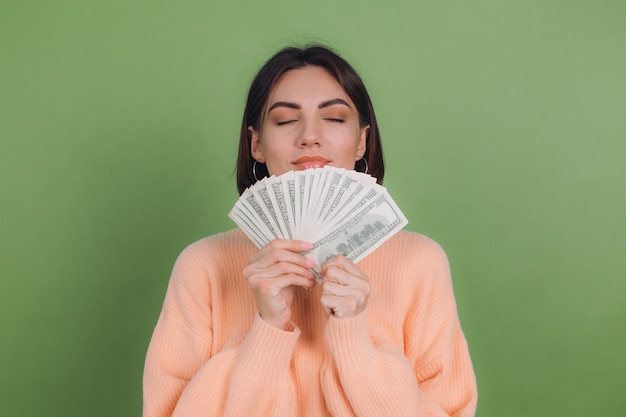 Jeune femme en pull pêche occasionnel isolé sur mur d'olive verte