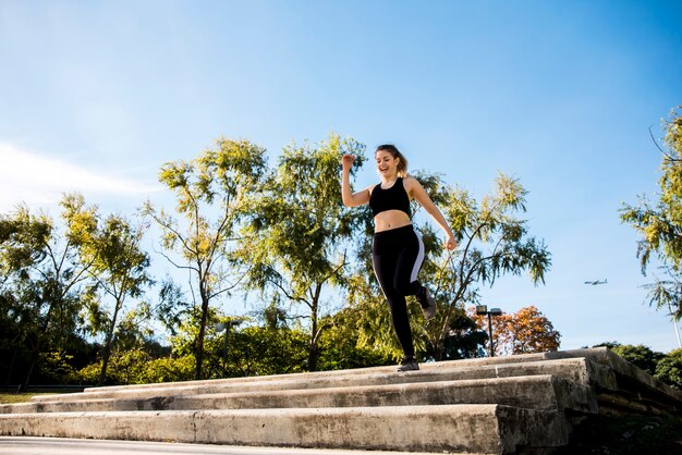 Jeune femme qui court à l&#39;extérieur avec des vêtements de sport