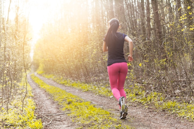 Jeune femme qui traverse la forêt