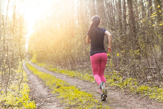 Jeune femme qui traverse la forêt