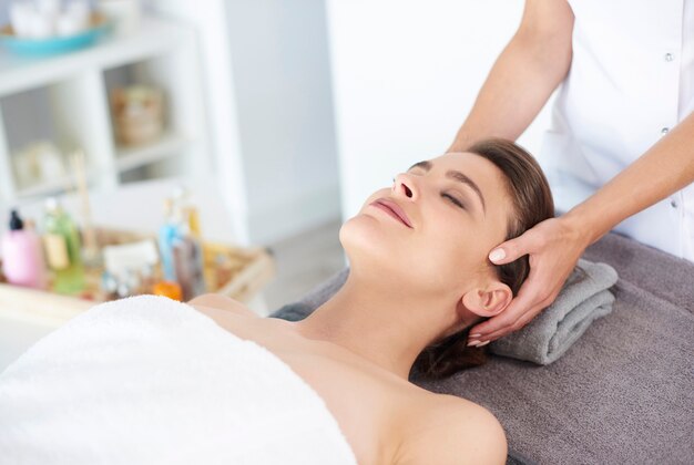 Jeune femme recevant un massage facial professionnel