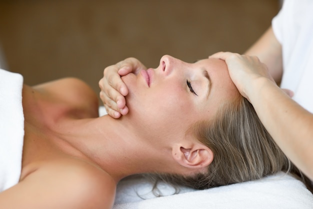 Jeune femme recevant un massage de tête dans un centre de spa.