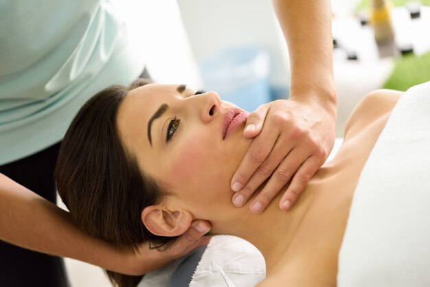 Jeune femme recevant un massage de la tête dans un centre de spa.