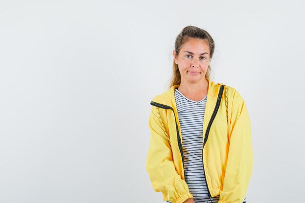 Jeune femme regardant la caméra en t-shirt, veste et à l'insatisfaction. vue de face.