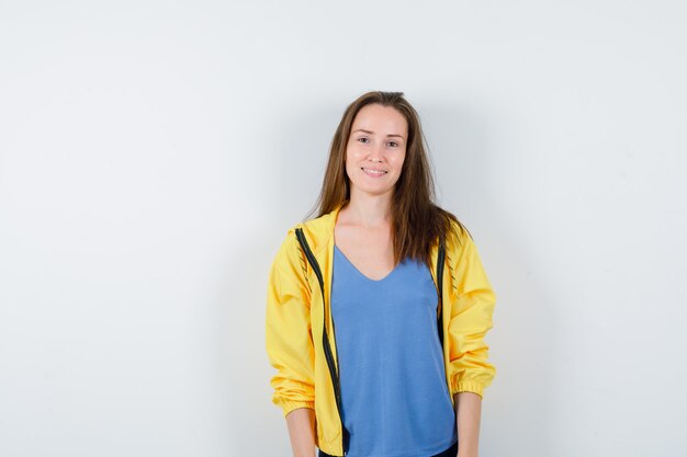 Jeune femme regardant la caméra en t-shirt, veste et ravissante, vue de face.