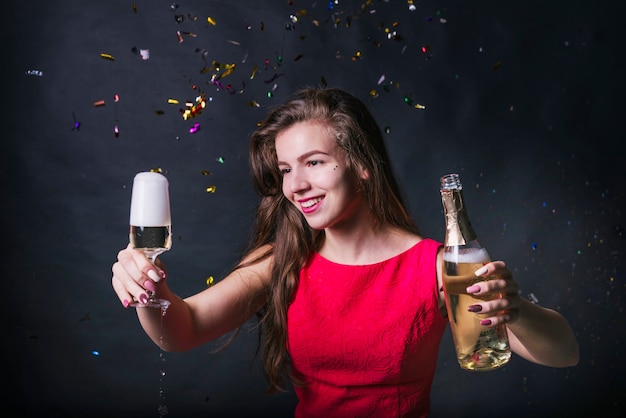 Jeune femme regardant une coupe de champagne