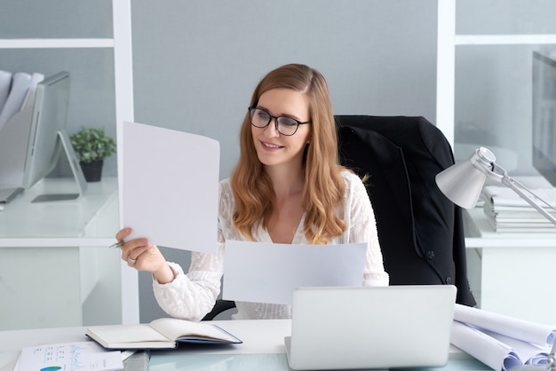 Jeune femme regardant des documents