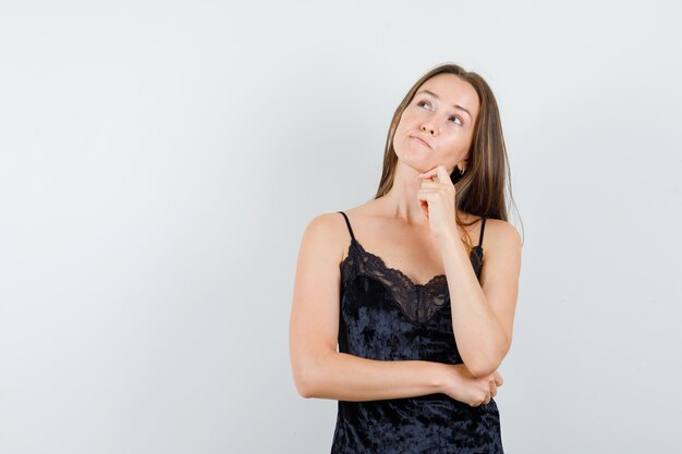 Jeune femme regardant en maillot noir et à la pensif.