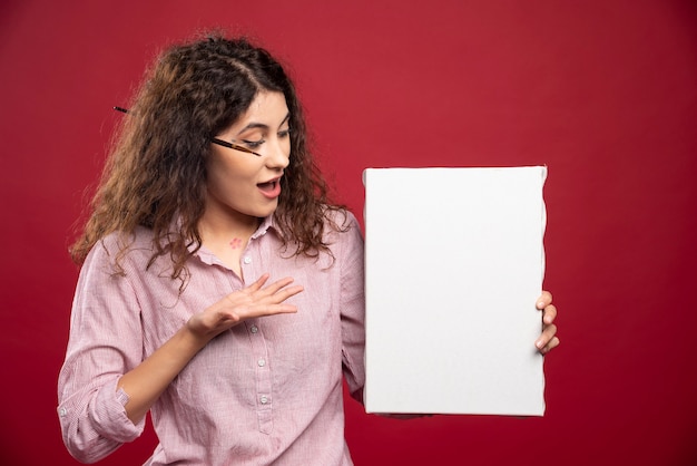 Jeune femme regardant la toile vide.