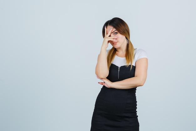 Jeune femme regardant à travers les doigts