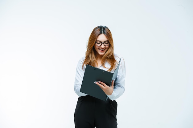 Jeune femme regardant à travers le presse-papiers