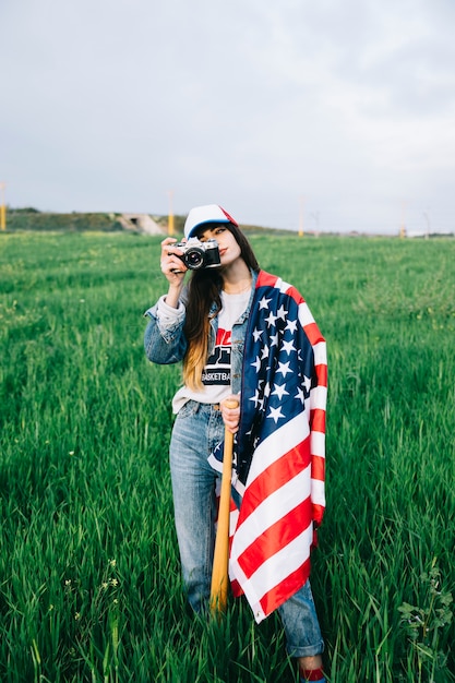 Jeune femme restant dans le champ avec le drapeau américain