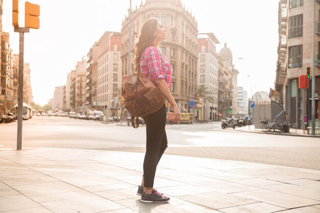 Jeune femme rêveuse debout sur la rue