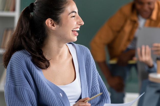 Photo gratuite jeune femme riant pendant la session d'étude