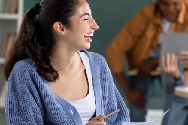 Jeune femme riant pendant la session d'étude