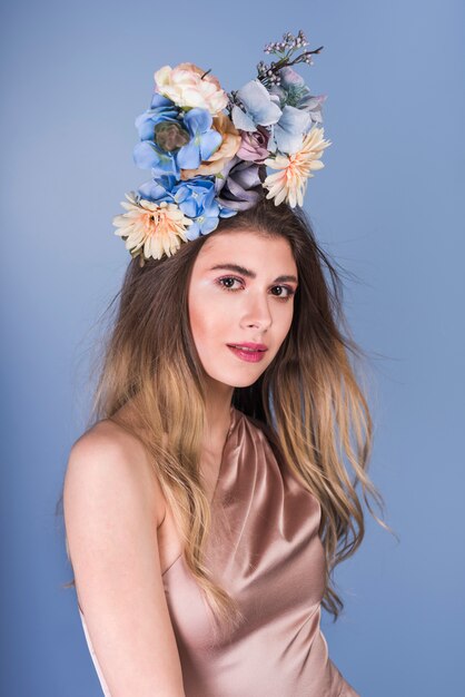 Jeune femme en robe avec de belles fleurs sur la tête