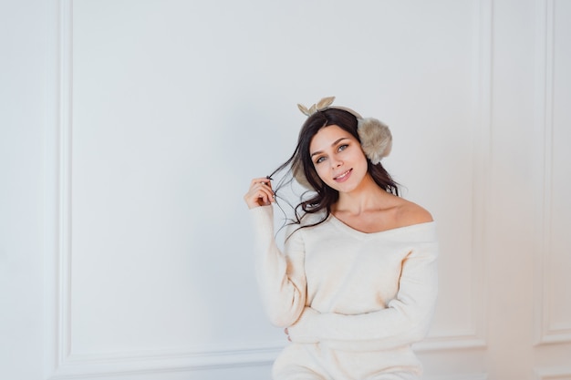 Jeune femme en robe blanche posant dans la chambre