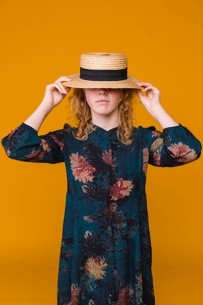 Jeune femme en robe avec chapeau beige