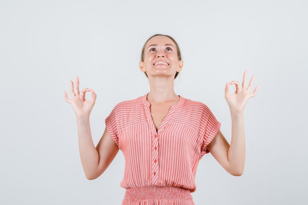 Photo gratuite jeune femme en robe rayée montrant le geste ok et à la vue de face, joyeuse.