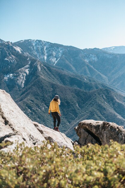 Jeune femme sur un rocher dans les montagnes