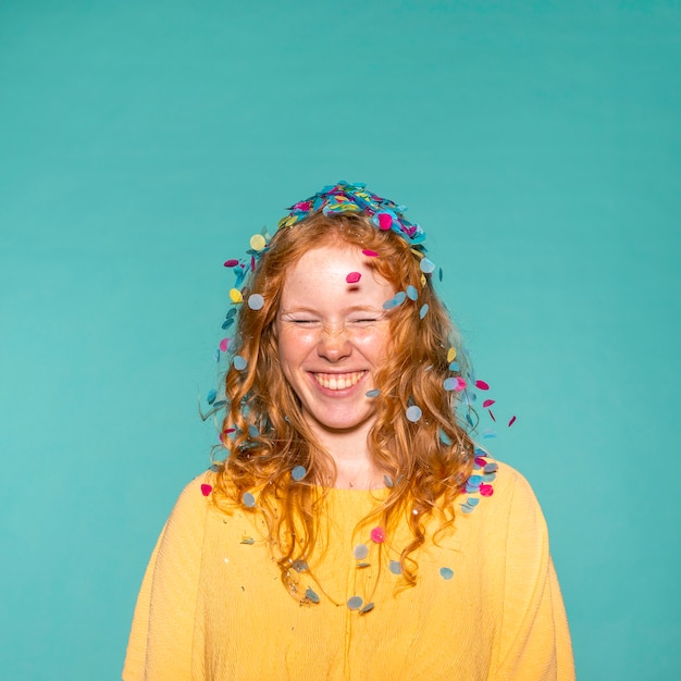 Photo gratuite jeune femme rousse faire la fête avec des confettis dans ses cheveux