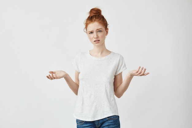 Jeune femme rousse mécontente gesticulant Femme confuse se disputant avec un petit ami. Blanc.