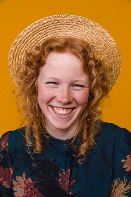 Jeune femme rousse rire et regarder la caméra