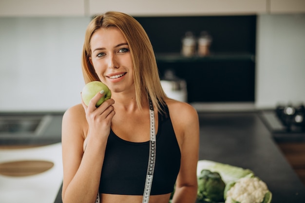 Jeune femme avec ruban à mesurer dans la cuisine