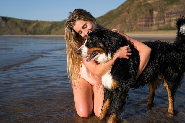 Photo gratuite jeune femme s'amusant avec un chien à la plage