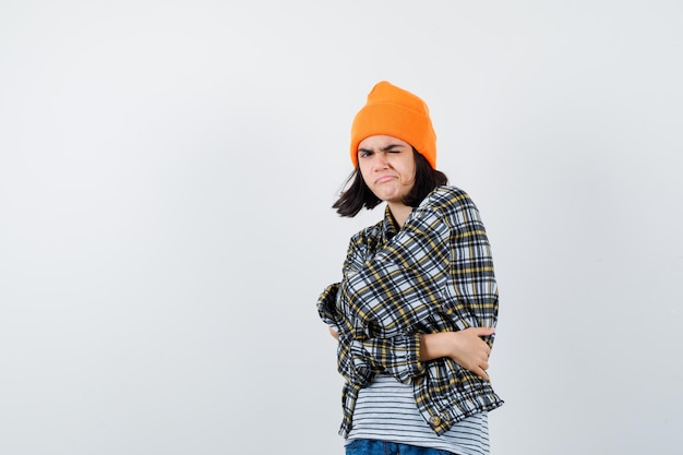 Photo gratuite jeune femme s'embrassant dans une chemise à carreaux chapeau orange à la suspicion