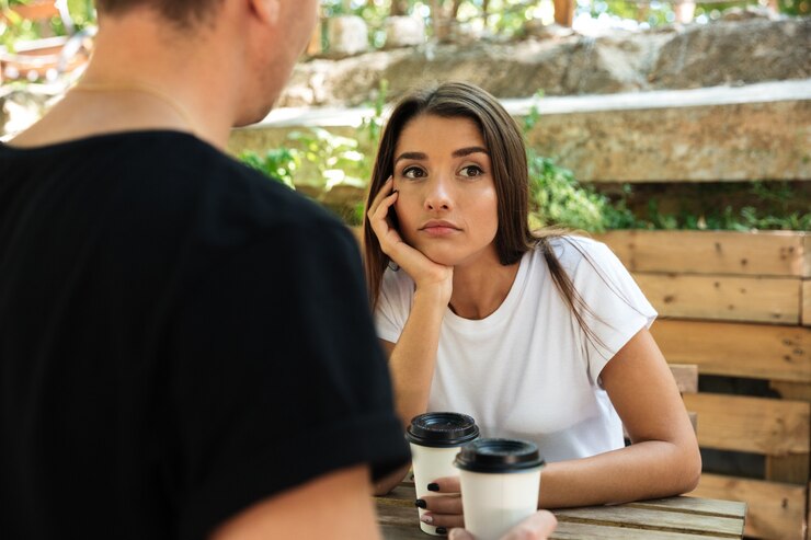 Photo gratuit jeune femme s'ennuie assis et boire du café avec son petit ami