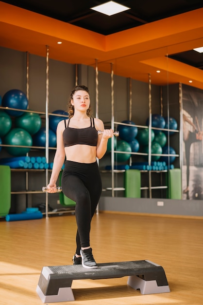 Photo gratuite jeune femme s'entraînant au gymnase