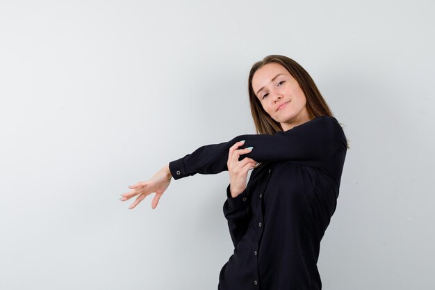 Jeune femme s'étendant les bras devant et à l'air détendu