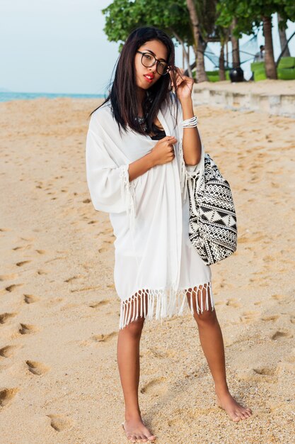 Jeune femme, à, sac boho, poser, sur, plage tropicale