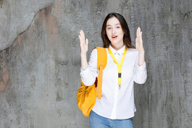 Jeune femme avec sac à dos montrant ses mains. Photo de haute qualité