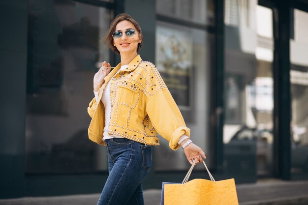 Jeune femme avec des sacs dans la ville