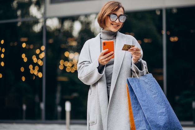 Jeune femme, à, sacs provisions, conversation téléphone