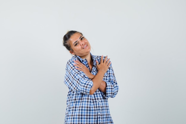 Jeune femme se câliner en chemise à carreaux et à la bien-aimée.