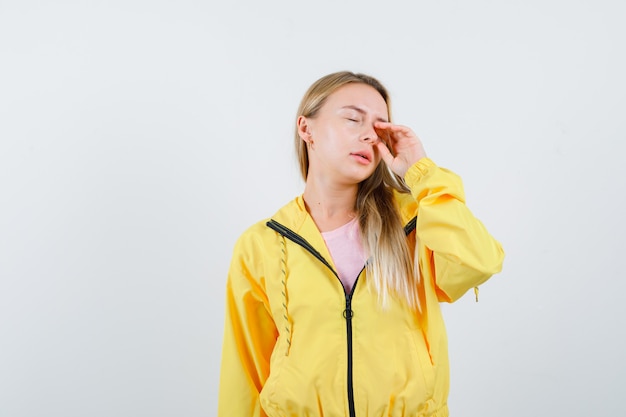 Jeune femme se frottant les yeux en t-shirt, veste et à la somnolence