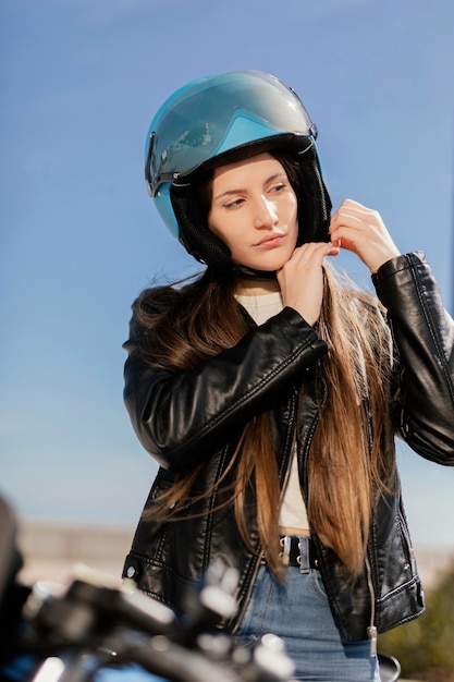 Photo gratuite jeune femme se préparant à rouler en moto dans la ville